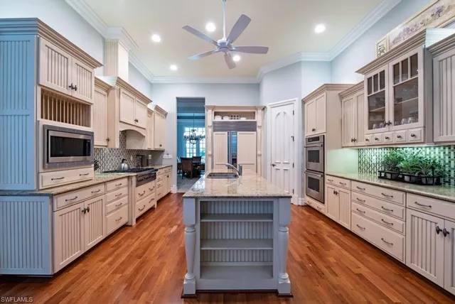 a large kitchen with stainless steel appliances kitchen island granite countertop a large counter top space a center island stainless steel appliances cabinets and a window