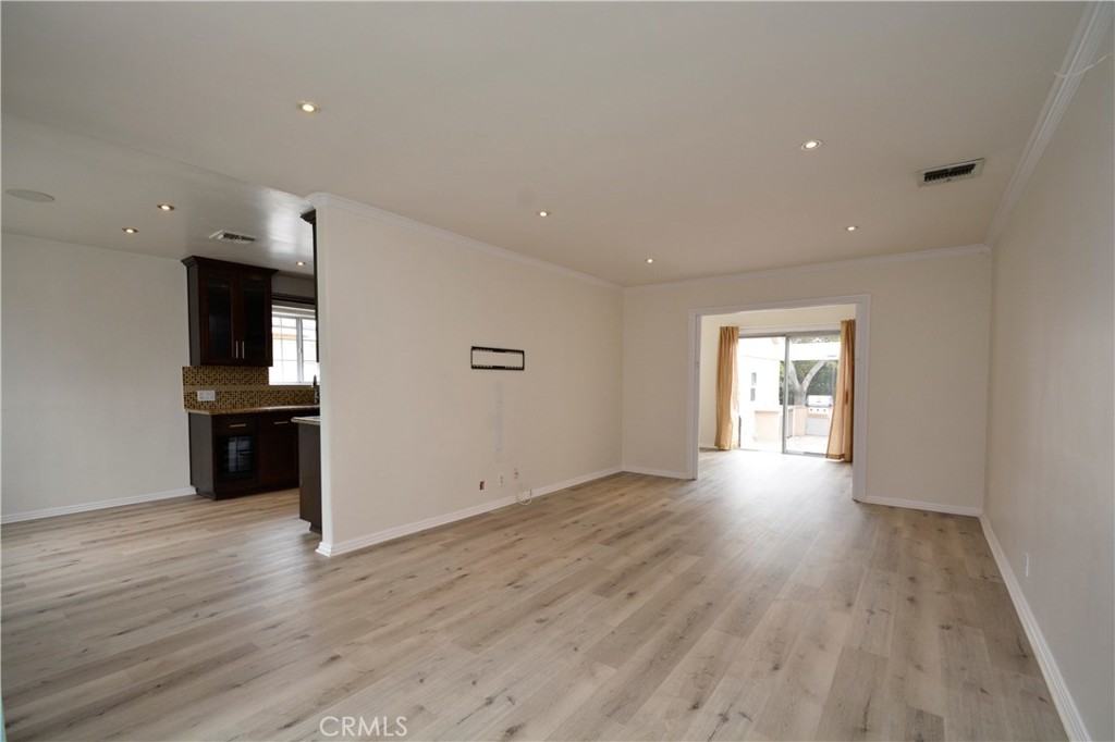 12301 Rives Avenue Downey, CA 90242 - Photo 5 of 20 a view of empty room with wooden floor and kitchen