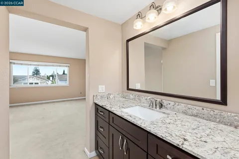 a bathroom with a granite countertop sink and a mirror