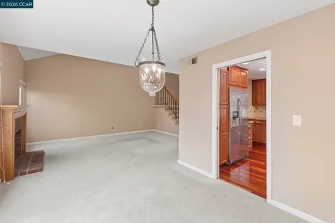 a view of an empty room with a fireplace and a window