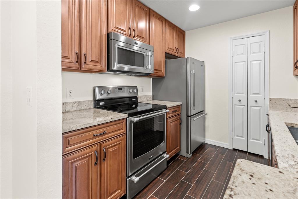 8911 Manor Loop, Unit 208 Lakewood Ranch, FL 34202 - Photo 13 of 49 a kitchen with stainless steel appliances granite countertop a stove a microwave and a refrigerator
