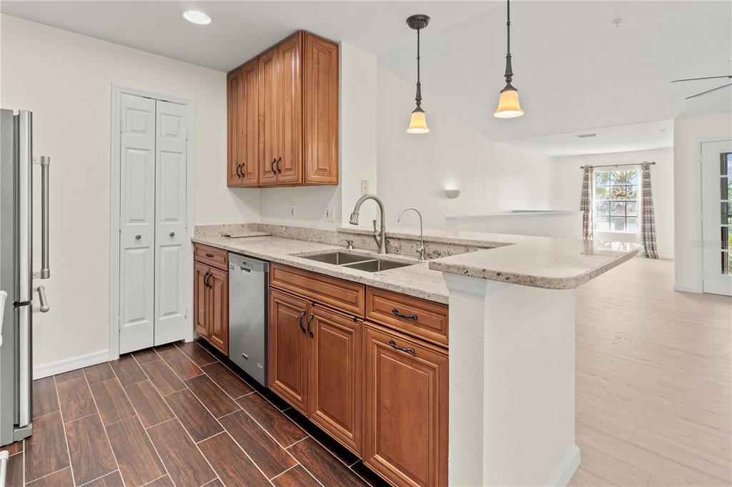 8911 Manor Loop, Unit 208 Lakewood Ranch, FL 34202 - Photo 24 of 49 a kitchen with a sink cabinets and wooden floor