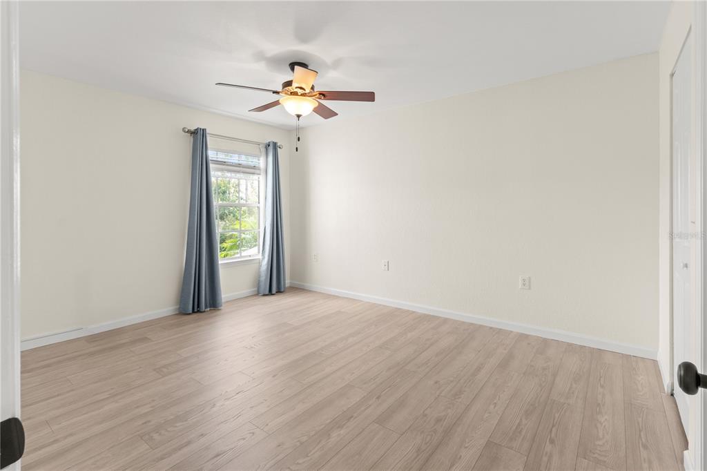 8911 Manor Loop, Unit 208 Lakewood Ranch, FL 34202 - Photo 25 of 49 a view of an empty room with wooden floor and a window