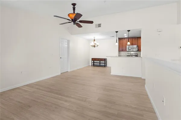 a kitchen with stainless steel appliances granite countertop a sink a stove a refrigerator cabinets and a wooden floor