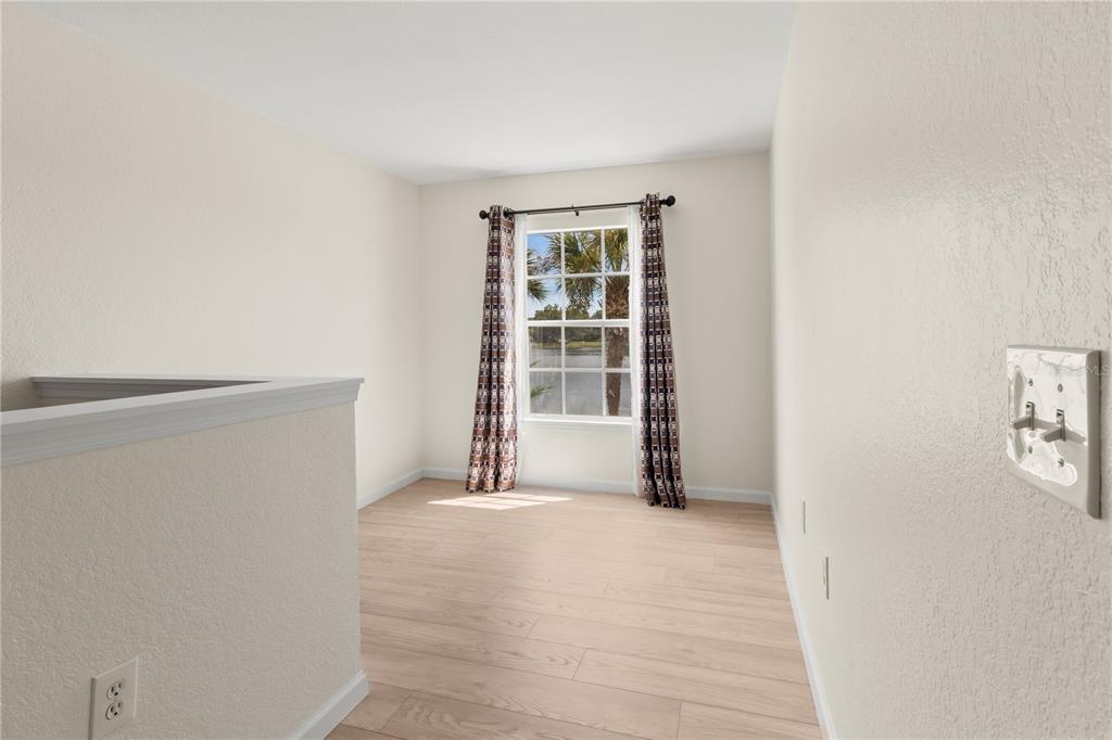 8911 Manor Loop, Unit 208 Lakewood Ranch, FL 34202 - Photo 35 of 49 a view of an empty room with wooden floor and a window