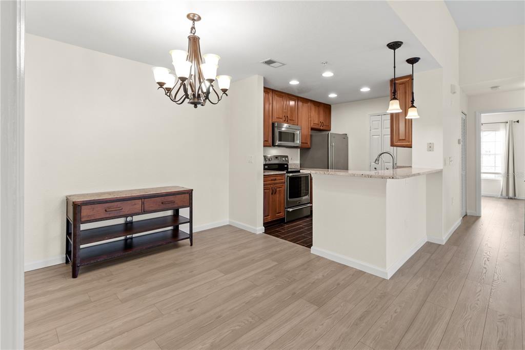 8911 Manor Loop, Unit 208 Lakewood Ranch, FL 34202 - Photo 37 of 49 a view of kitchen with livingroom and wooden floor