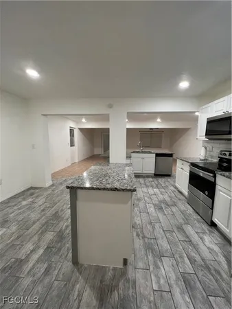 a large kitchen with stainless steel appliances granite countertop a sink and a stove