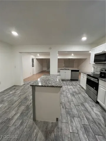a large kitchen with stainless steel appliances granite countertop a sink and a stove