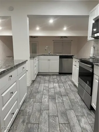 a large white kitchen with a stove top oven a sink and dishwasher