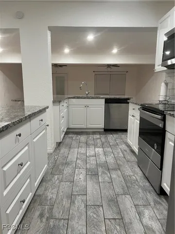 a large white kitchen with a stove top oven a sink and dishwasher