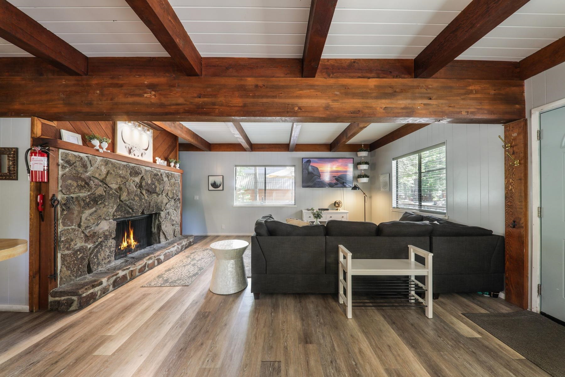 5656 Victoria Road Carnelian Bay, CA 96140 - Photo 9 of 28 a living room with furniture a fireplace and a table