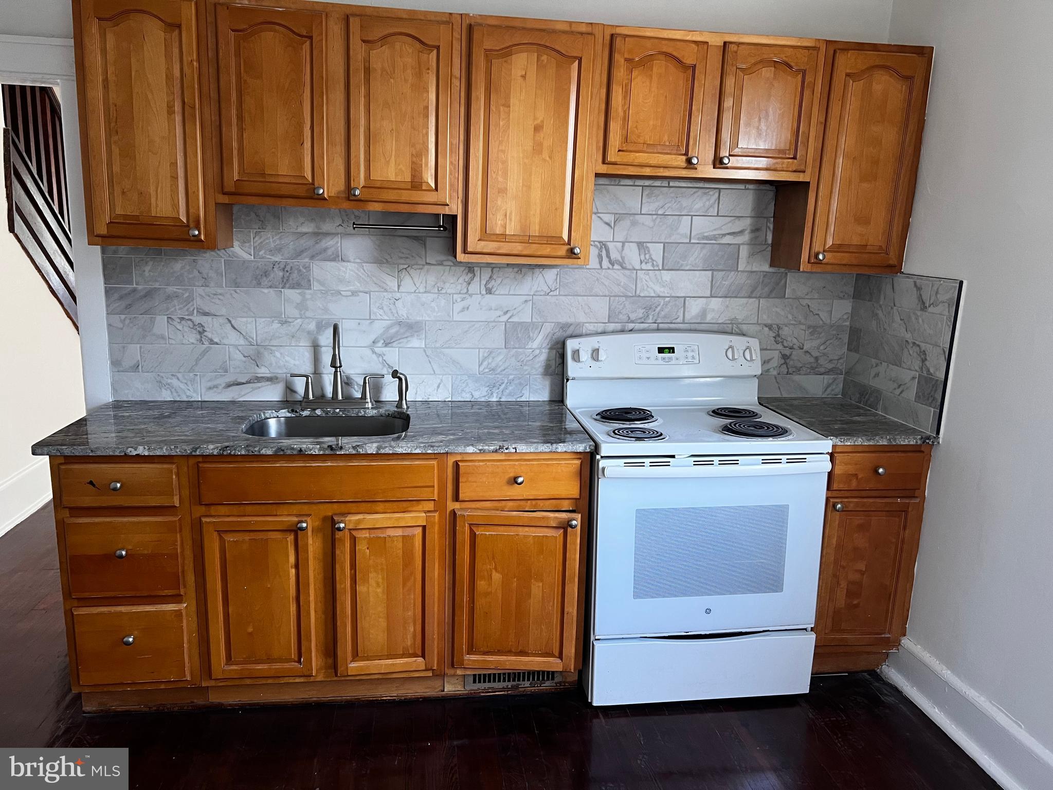 529 Bridgeboro Street Riverside, NJ 08075 - Photo 3 of 7 a kitchen with granite countertop wooden cabinets and white appliances