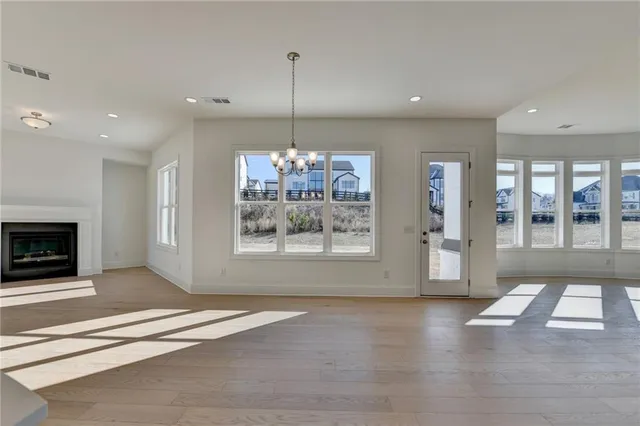 a view of an empty room with a window and a kitchen