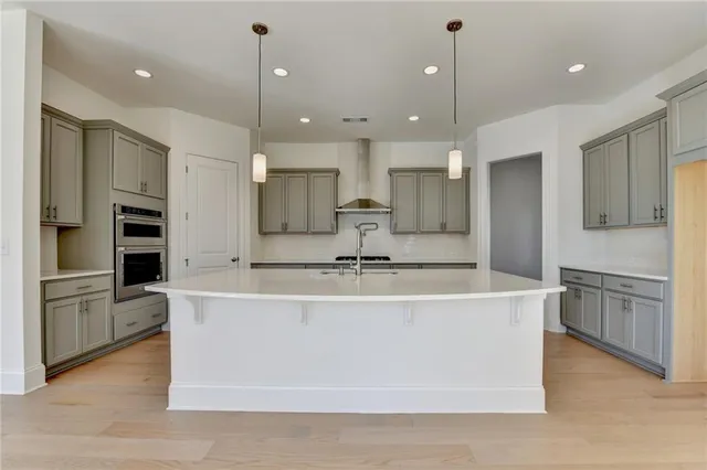a large white kitchen with a large counter top and stainless steel appliances