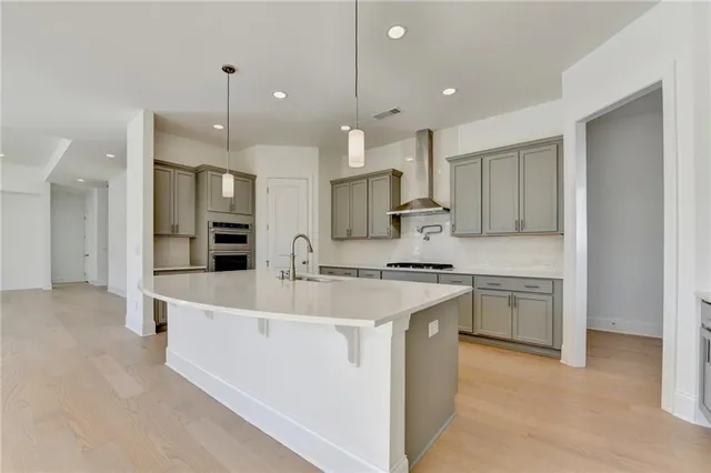 a view of a kitchen with kitchen island a sink wooden floor and a refrigerator