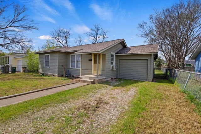 a view of a house with a backyard and a tree
