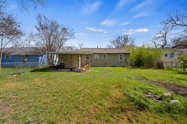 a view of a house with backyard and tree
