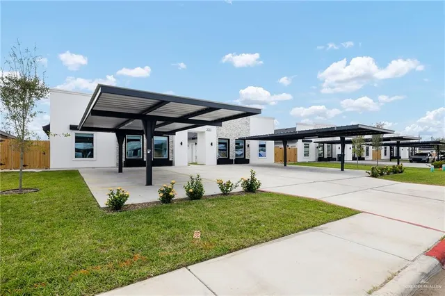 a front view of a house with a garden and yard