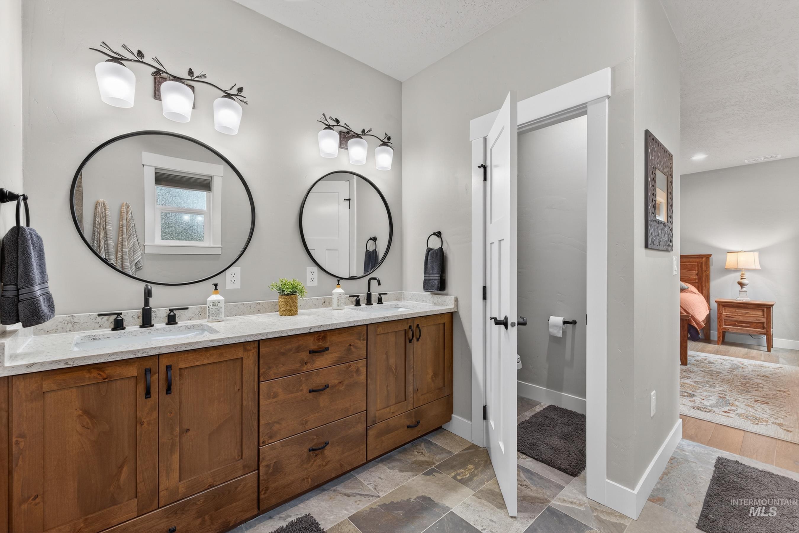 10191 Timberrim Drive Cascade, ID 83611 - Photo 26 of 44 Full bathroom featuring double vanity, connected bathroom, and light stone finish floors
