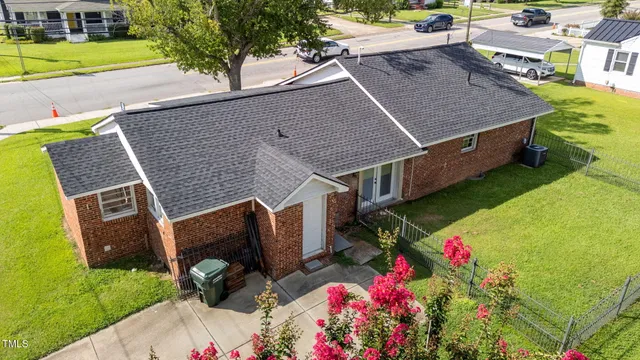 a backyard of a house with wooden fence and large trees