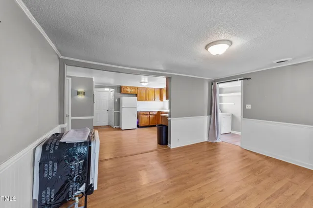 a view of empty room with wooden floor