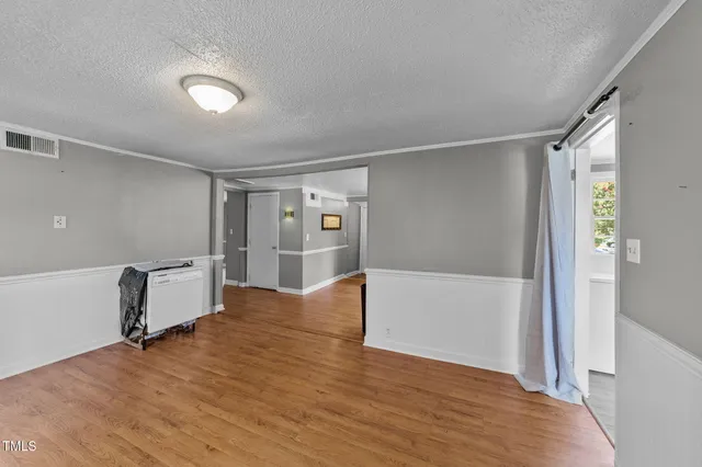 a view of empty room with wooden floor