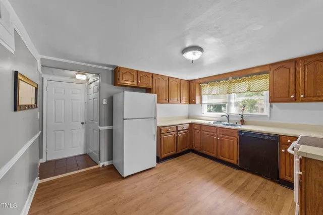 a kitchen with stainless steel appliances granite countertop a refrigerator a sink dishwasher a stove with wooden cabinets and floor