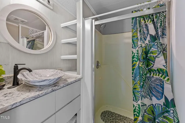 a bathroom with a granite countertop sink a mirror and vanity