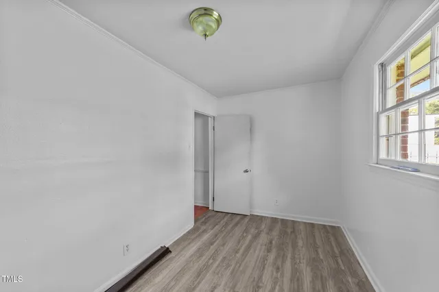 a view of room with window and wooden floor