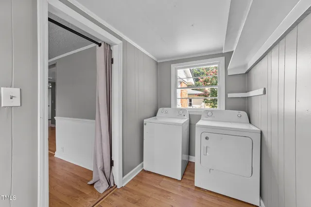 a view of washer and dryer with bathroom in the background