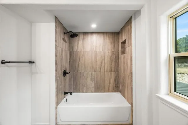 an aerial view of residential house with outdoor space and trees all around