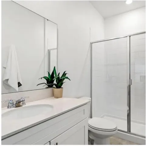 a bathroom with a sink a toilet and shower