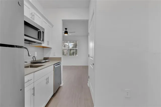 a kitchen with stainless steel appliances granite countertop white cabinets and window