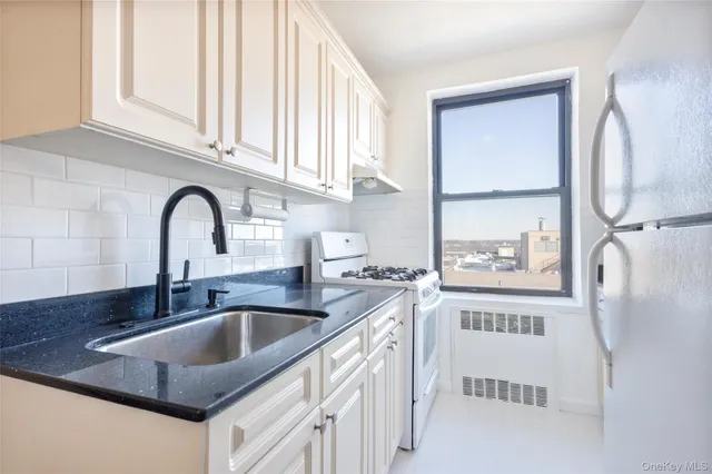 a kitchen with stainless steel appliances granite countertop a sink and a refrigerator
