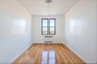 102-36 64th Avenue, Unit 6B Queens, NY 11375 - Photo 8 of 12 an empty room with wooden floor and windows