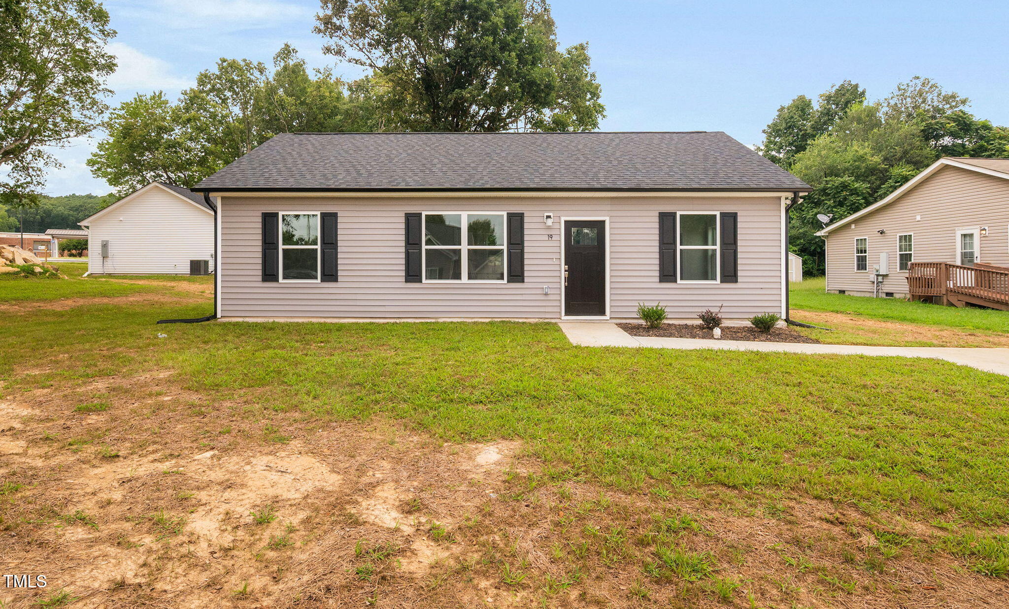 a front view of a house with yard and trees