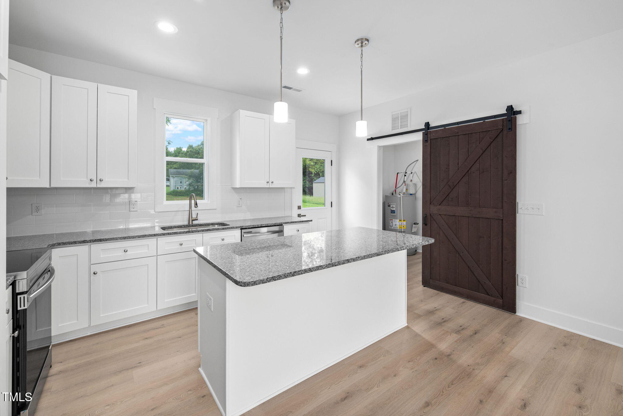 19 Southern Village Drive Roxboro, NC 27573 - Photo 12 of 31 a kitchen with a sink a refrigerator a window and wooden floor