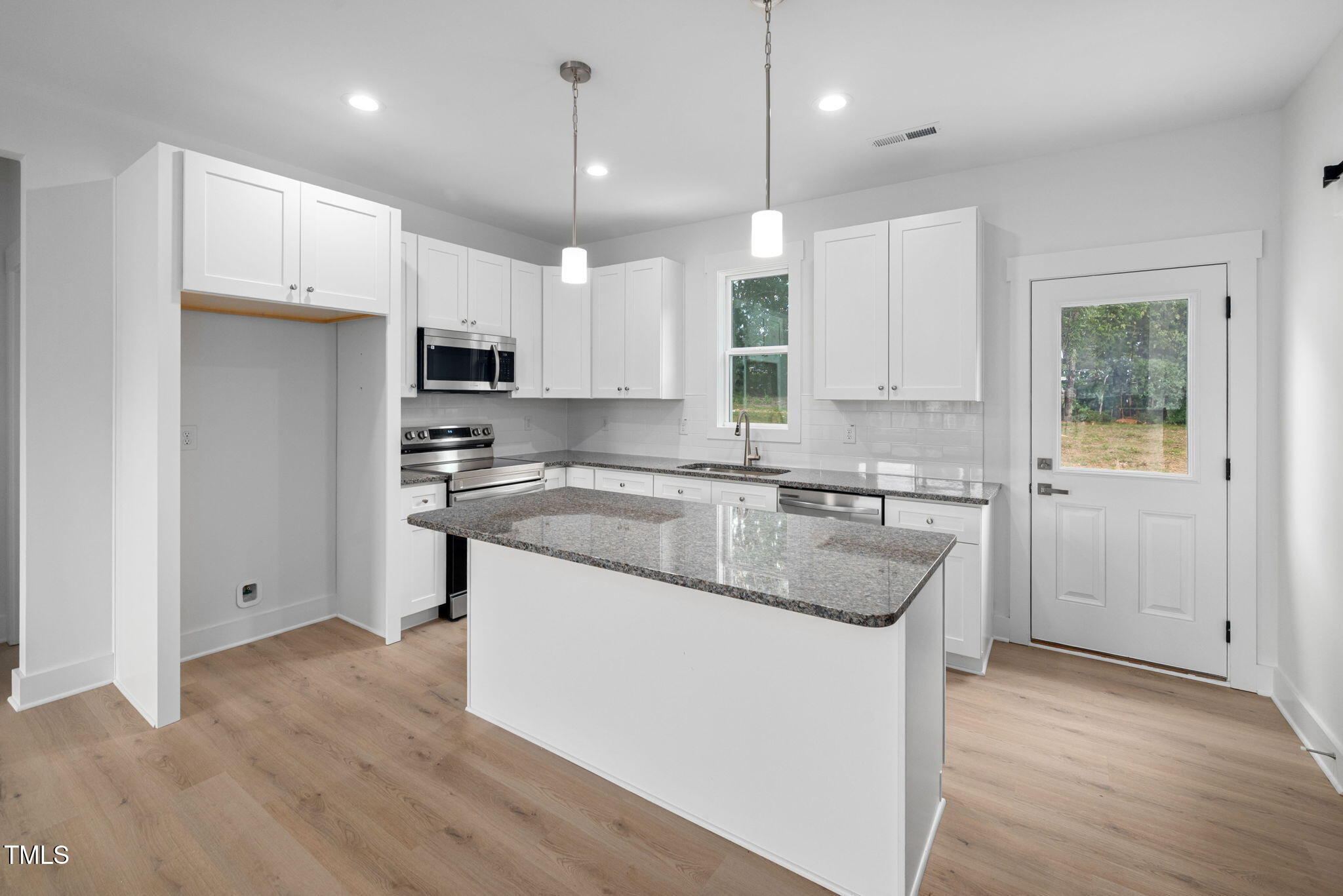 19 Southern Village Drive Roxboro, NC 27573 - Photo 8 of 31 a kitchen with kitchen island granite countertop a sink a counter space appliances and cabinets