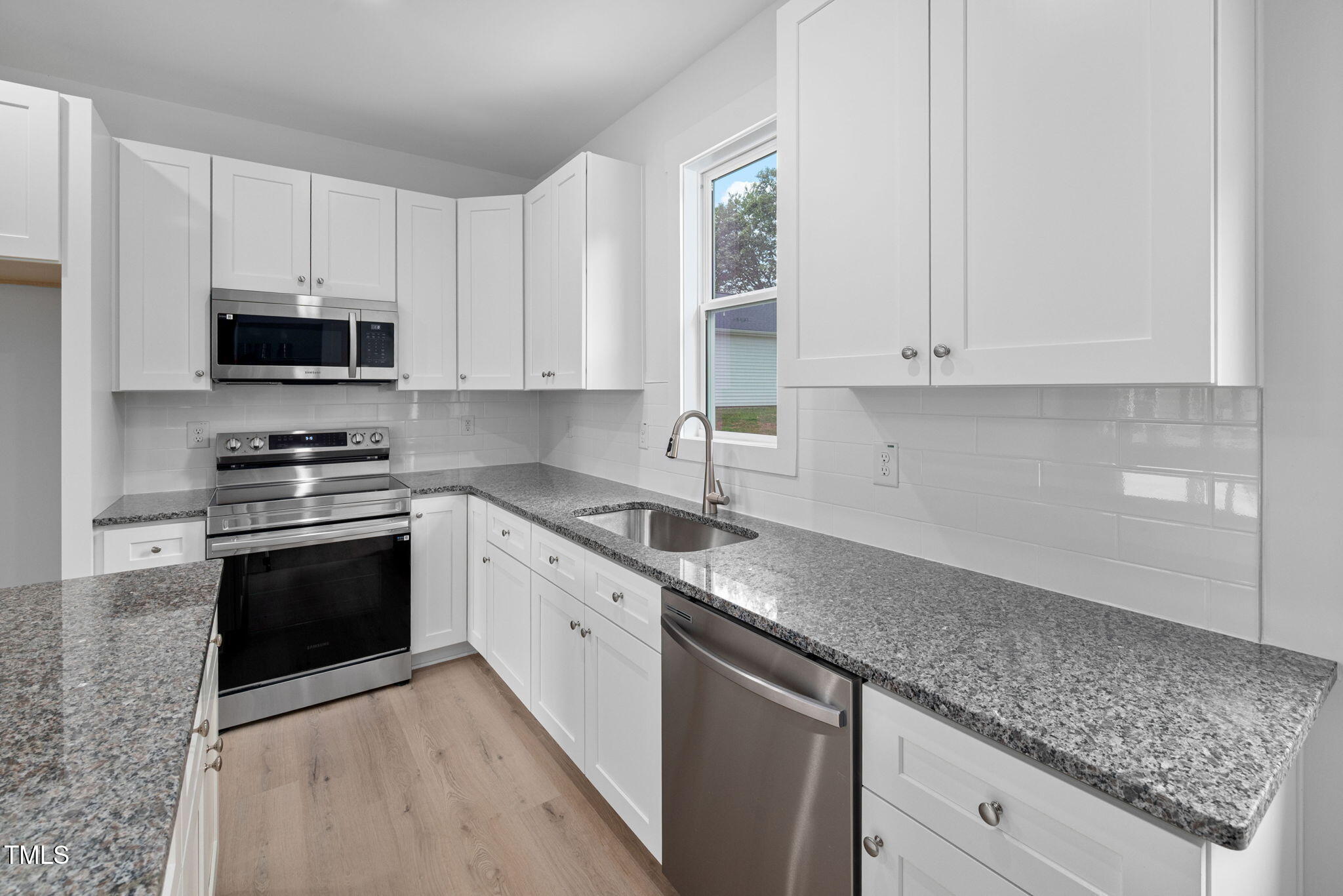 19 Southern Village Drive Roxboro, NC 27573 - Photo 9 of 31 a kitchen with granite countertop a sink stainless steel appliances and white cabinets