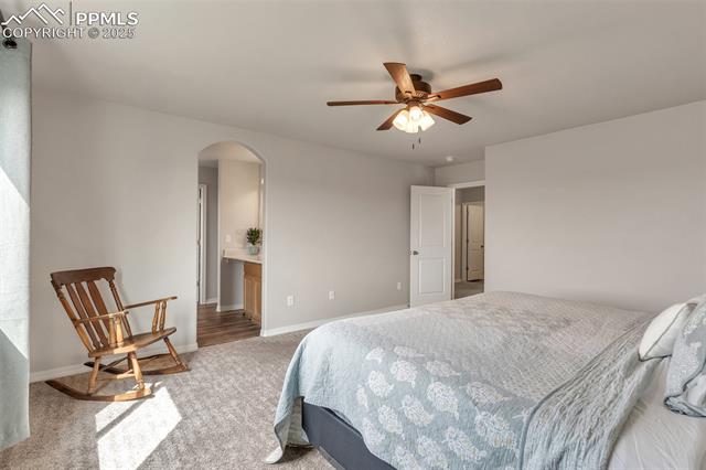11053 Avena Road Peyton, CO 80831 - Photo 18 of 27 Bedroom featuring arched walkways, carpet flooring, and ceiling fan