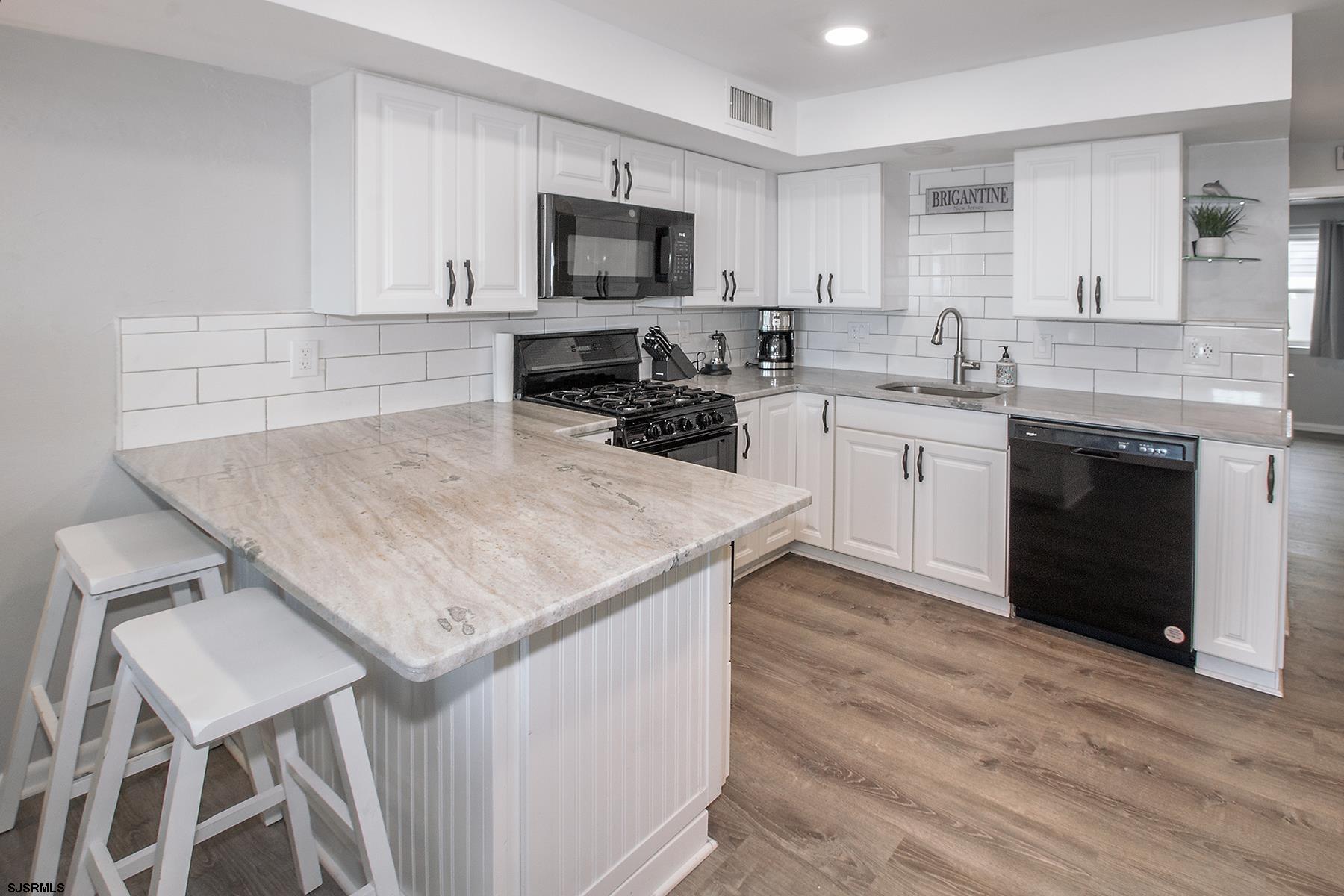 1101 East Brigantine Avenue, Unit 2 Brigantine, NJ 08203 - Photo 4 of 13 a kitchen with a stove a sink and a refrigerator