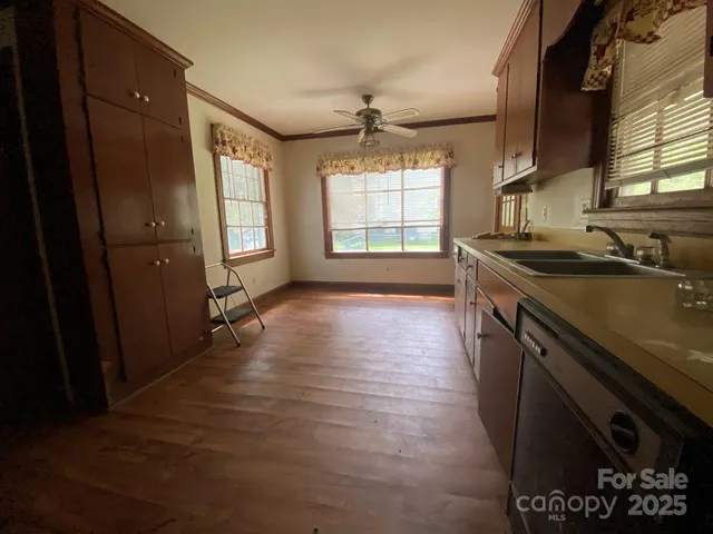 a kitchen with granite countertop a sink stove and cabinets