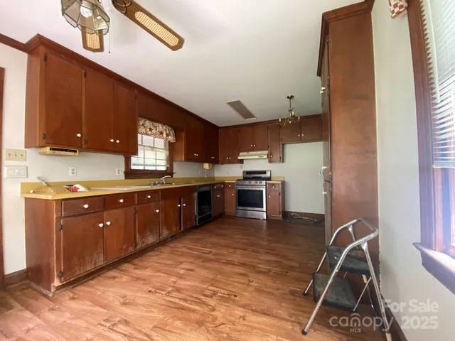a kitchen with stainless steel appliances granite countertop a stove sink and cabinets