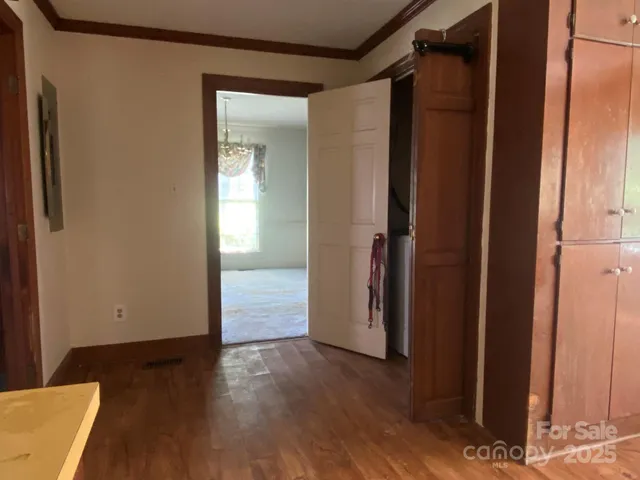 an empty room with wooden floor and a bathroom