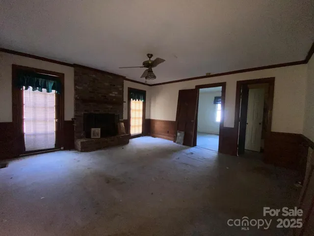 a view of empty room with fireplace and fan