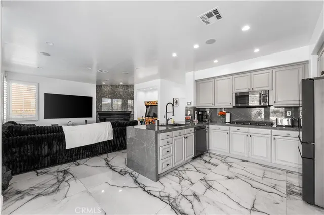 a kitchen with stainless steel appliances granite countertop a refrigerator and a stove
