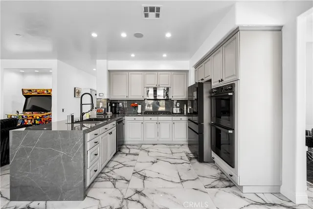 a kitchen with granite countertop white cabinets and stainless steel appliances