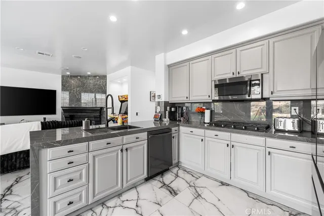 a kitchen with stainless steel appliances granite countertop a stove a sink and a microwave