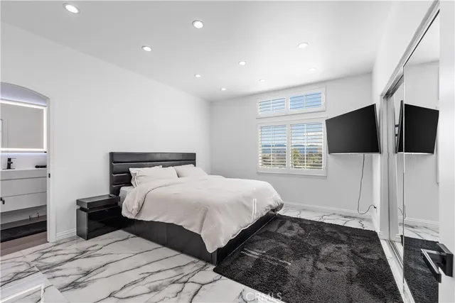 a bedroom with a bed and a large mirror