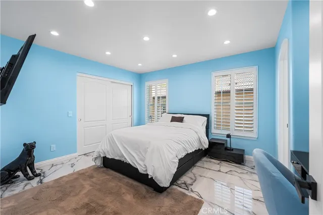a spacious bedroom with a bed and a flat screen tv